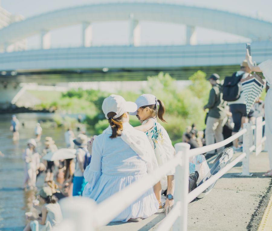 親子が川と橋を眺める夏の日