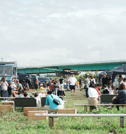 橋の下の広場で人々が飲食や交流を楽しむ野外イベント。